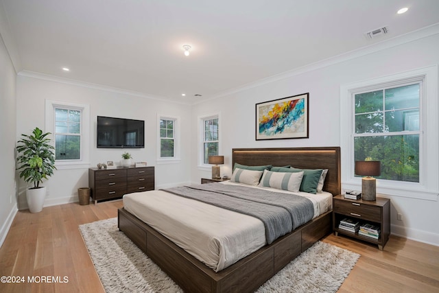 bedroom featuring ornamental molding and light hardwood / wood-style flooring