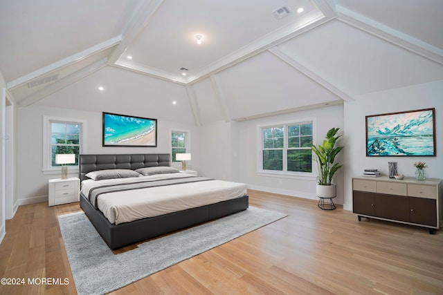 bedroom featuring lofted ceiling with beams and light hardwood / wood-style floors