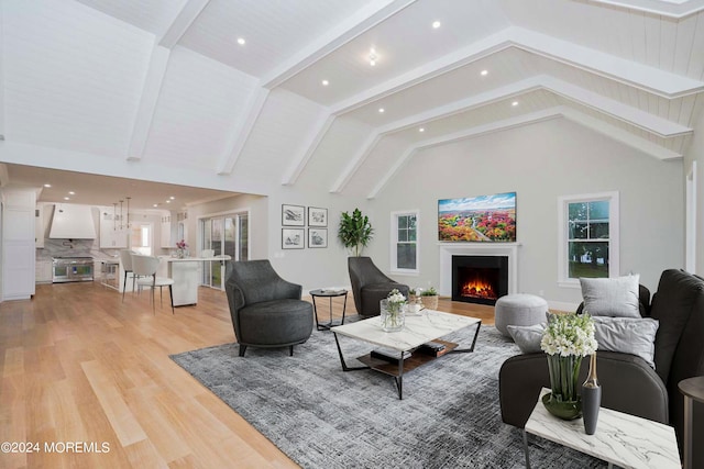 living room featuring lofted ceiling with beams and light wood-type flooring