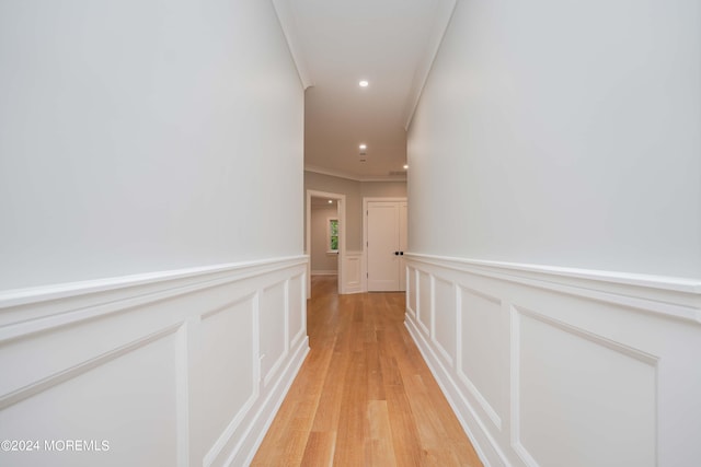 corridor with crown molding and light wood-type flooring