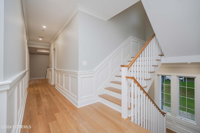 stairway featuring crown molding and hardwood / wood-style floors