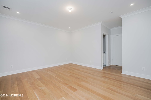 spare room featuring crown molding and light hardwood / wood-style flooring