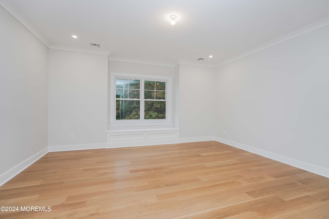 empty room with light wood-type flooring and crown molding