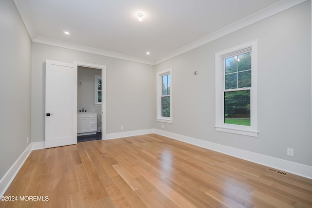 unfurnished room with light hardwood / wood-style flooring, crown molding, and a healthy amount of sunlight