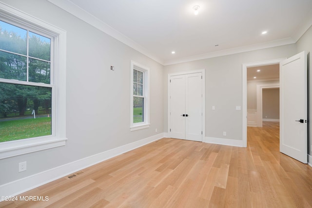 unfurnished bedroom featuring crown molding and light hardwood / wood-style floors