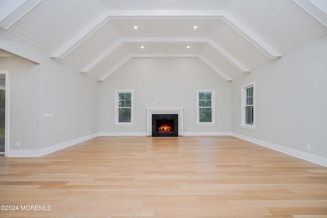 unfurnished living room featuring light wood-type flooring, wood ceiling, high vaulted ceiling, and a wealth of natural light