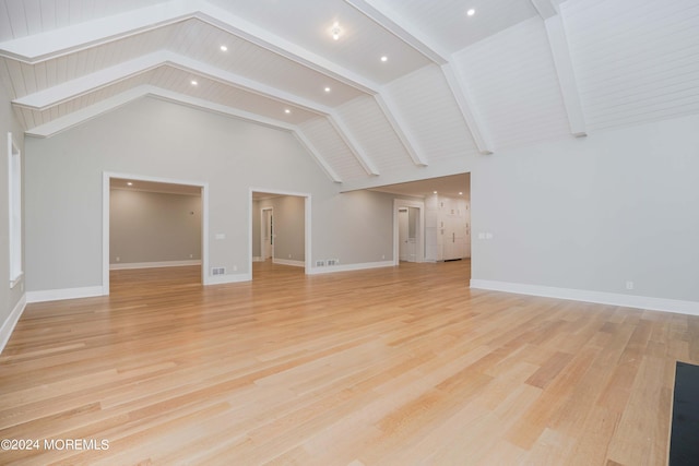 unfurnished living room featuring light wood-type flooring, wood ceiling, beam ceiling, and high vaulted ceiling