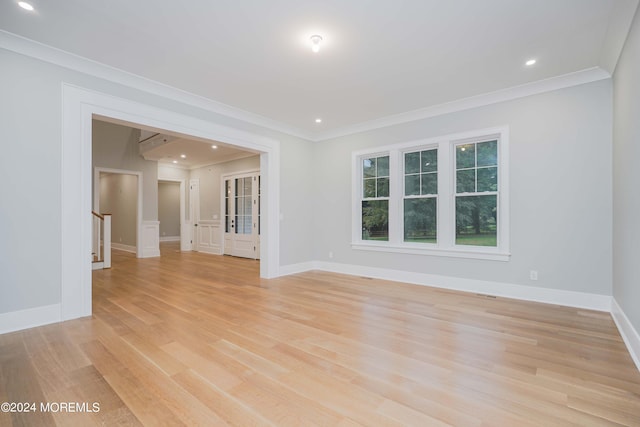 unfurnished room with ornamental molding and light wood-type flooring