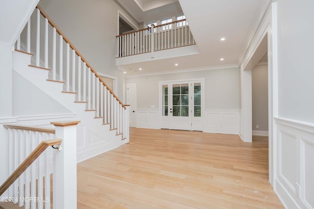 entrance foyer featuring ornamental molding and light hardwood / wood-style floors