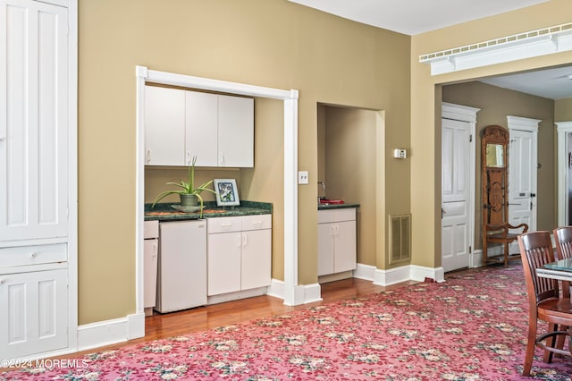 interior space featuring light hardwood / wood-style floors and white cabinetry