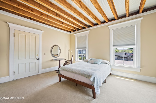 carpeted bedroom with beamed ceiling