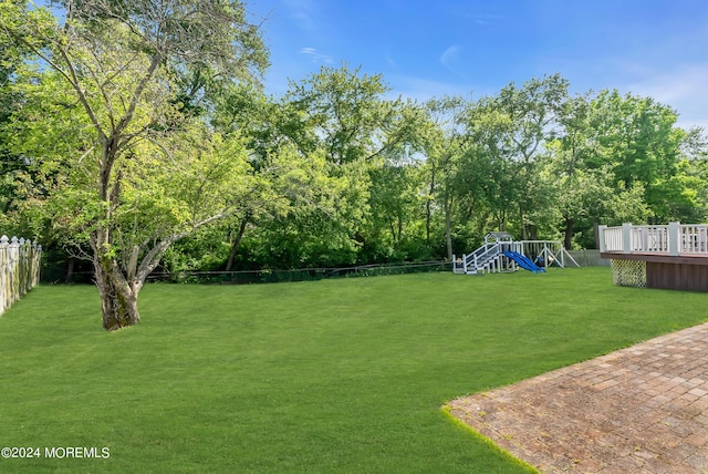 view of yard featuring a playground and a deck