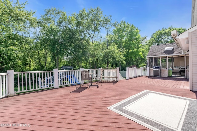 wooden terrace featuring grilling area and a sunroom