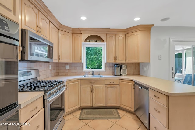 kitchen with kitchen peninsula, stainless steel appliances, and light brown cabinetry