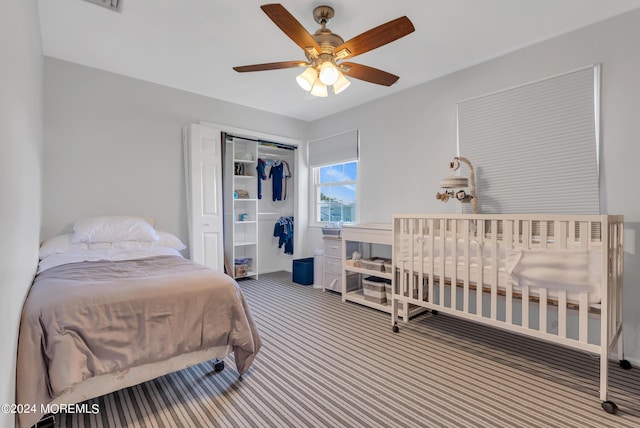 carpeted bedroom featuring ceiling fan and a closet