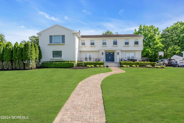 view of front of house with french doors and a front lawn