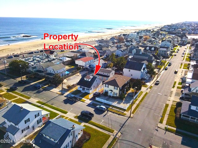 birds eye view of property with a water view and a beach view