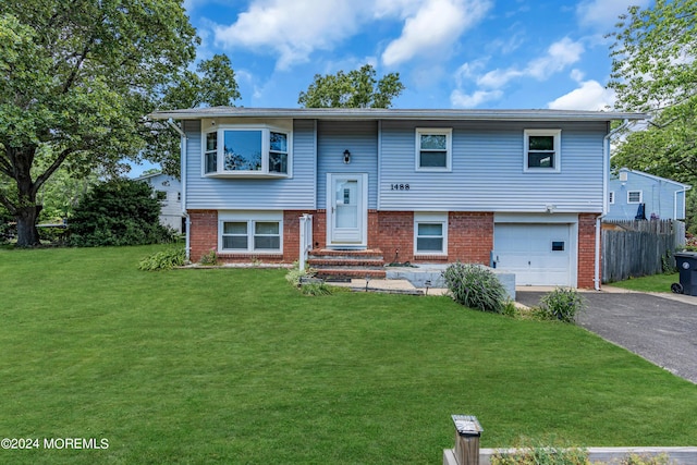 raised ranch with a garage and a front lawn