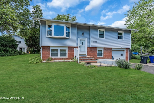 split foyer home featuring a garage and a front lawn