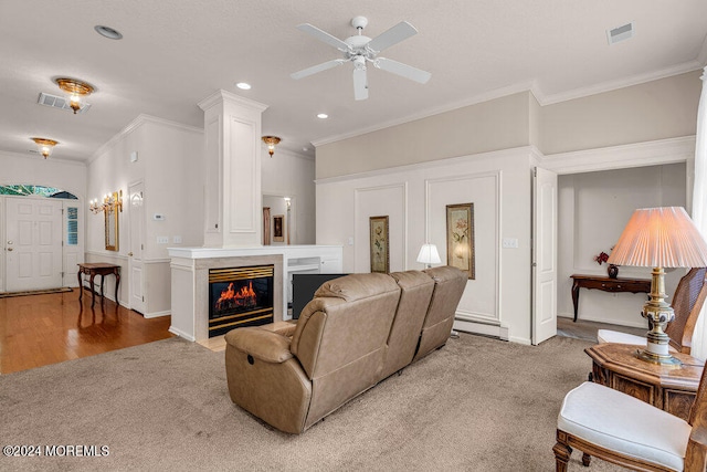 living room featuring ceiling fan, a baseboard heating unit, hardwood / wood-style flooring, and crown molding