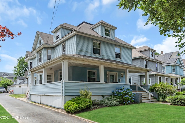 view of front of house featuring covered porch and a front yard