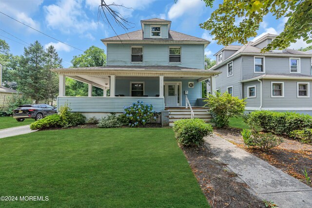 view of front of home with a porch and a front lawn