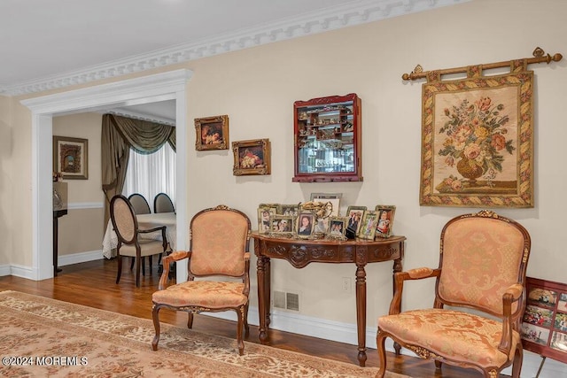 living area with hardwood / wood-style floors and crown molding