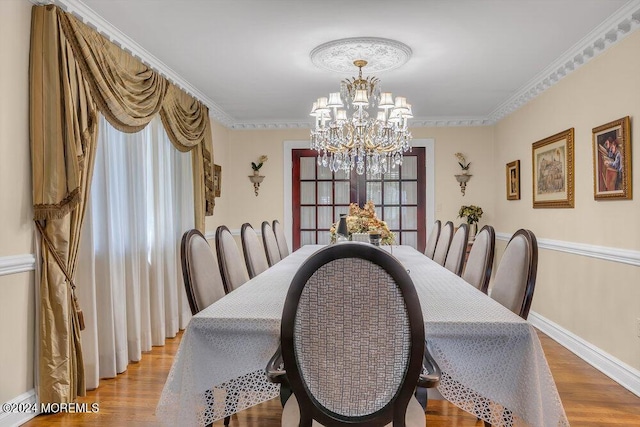 dining space featuring a chandelier, hardwood / wood-style flooring, and crown molding