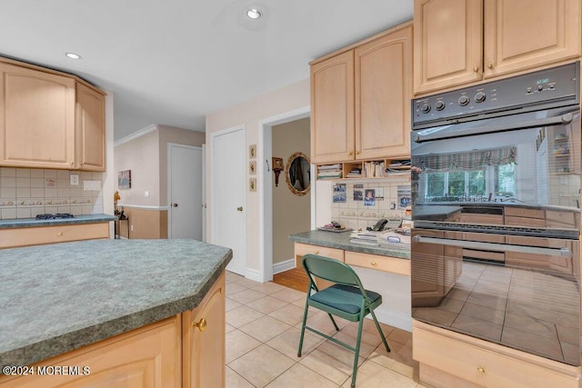 kitchen with light brown cabinetry, tasteful backsplash, light tile patterned floors, and double oven