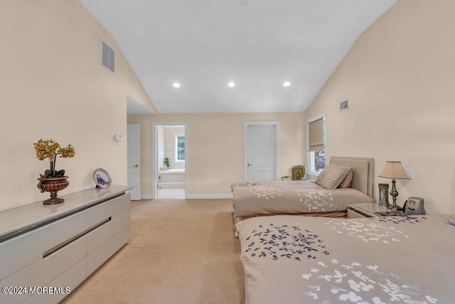 carpeted bedroom with ensuite bathroom and high vaulted ceiling