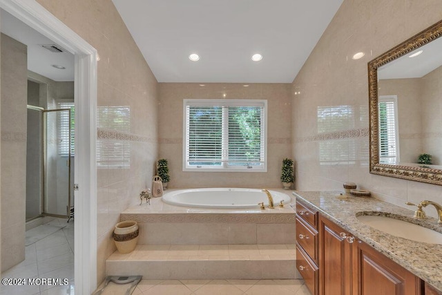 bathroom featuring tile patterned flooring, vanity, tile walls, and vaulted ceiling