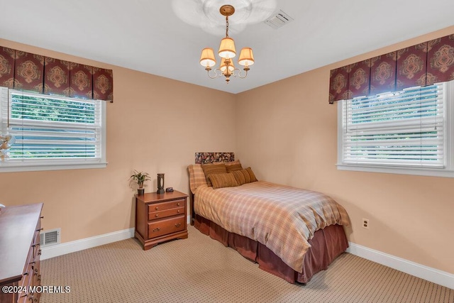 carpeted bedroom featuring a chandelier