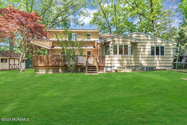 back of property with a deck, a storage shed, and a lawn