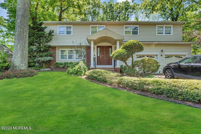 view of front of home featuring a front yard and a garage