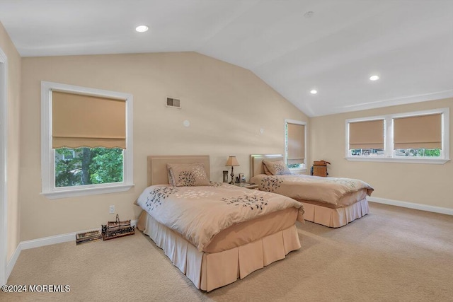 bedroom with light colored carpet and lofted ceiling