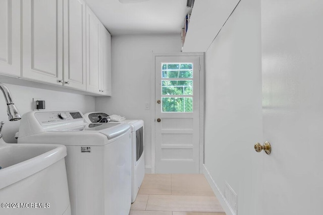 laundry area featuring sink, light tile patterned flooring, cabinets, and independent washer and dryer