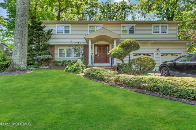 65 Chicanos Dr, Lakewood, NJ 08701 - view of front facade with a front lawn, an attached garage, and brick siding