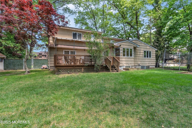 65 Chicanos Dr, Lakewood, NJ 08701 - back of property featuring a trampoline and a wooden deck