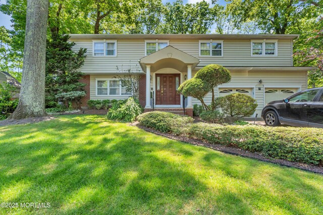 65 Chicanos Dr, Lakewood, NJ 08701 - view of front of house featuring a front lawn, an attached garage, and brick siding