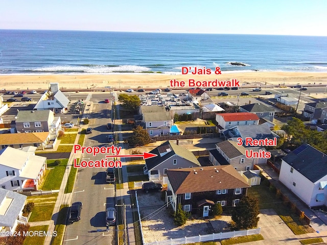 drone / aerial view with a water view and a beach view