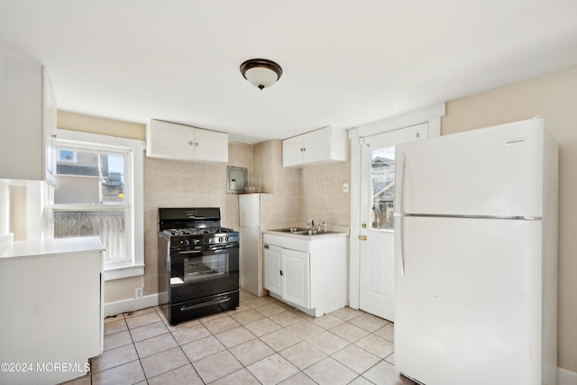 107 18th Ave, Belmar, NJ 07719 - kitchen with freestanding refrigerator, gas stove, white cabinets, and light tile patterned floors