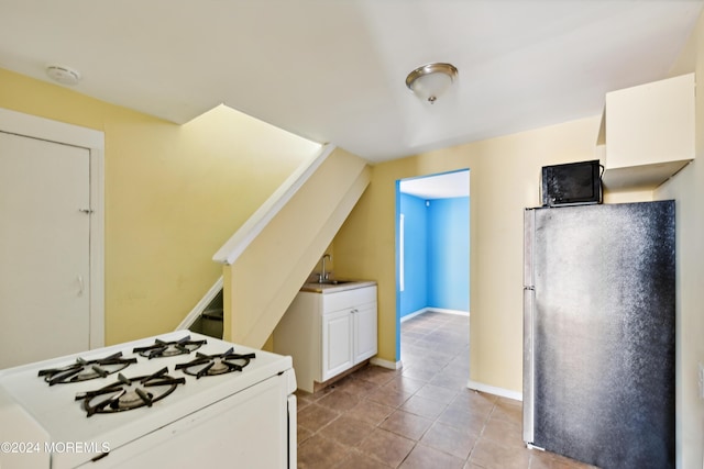107 18th Ave, Belmar, NJ 07719 - kitchen featuring freestanding refrigerator, white range with gas cooktop, white cabinets, tile patterned floors, and a sink