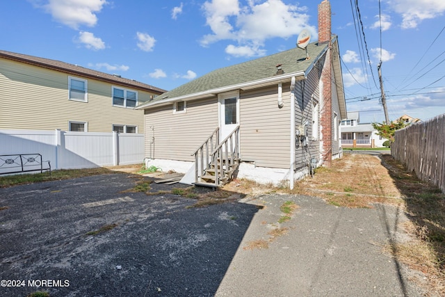 107 18th Ave, Belmar, NJ 07719 - rear view of house featuring entry steps, a chimney, and a shingled roof
