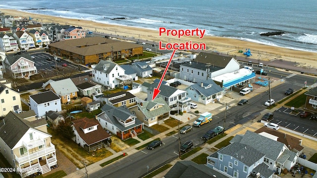 drone / aerial view featuring a water view and a beach view