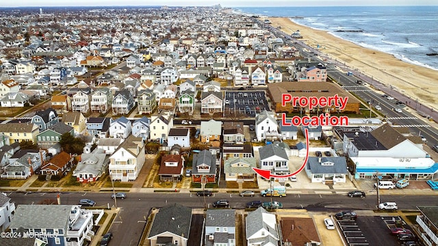 birds eye view of property featuring a water view and a beach view