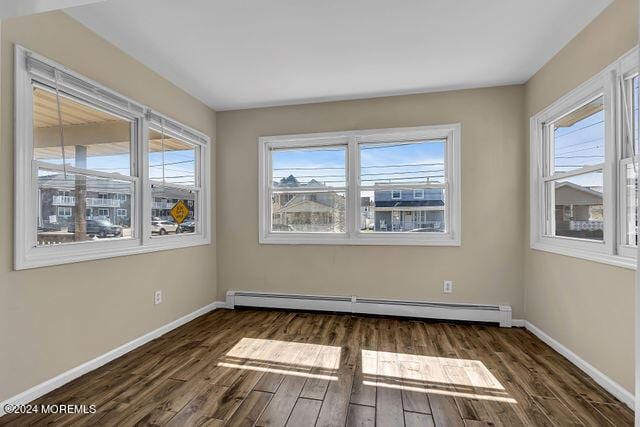 unfurnished room featuring a baseboard radiator and dark wood-type flooring