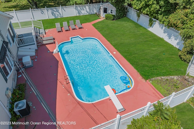 view of pool featuring a yard, a diving board, and a patio area