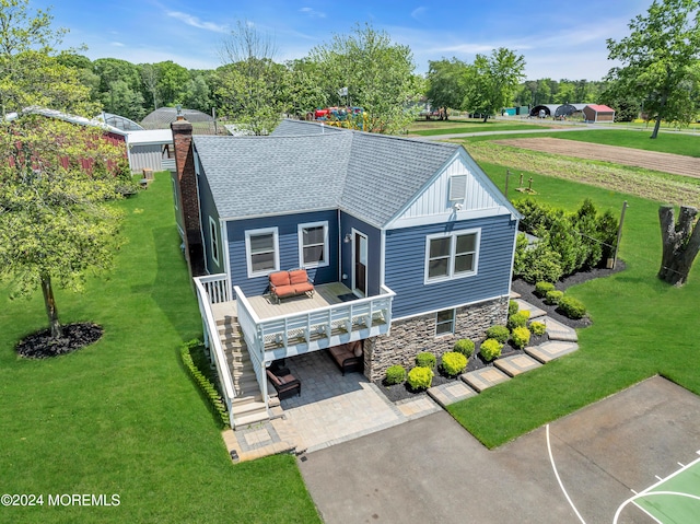 view of front facade with a wooden deck and a front yard