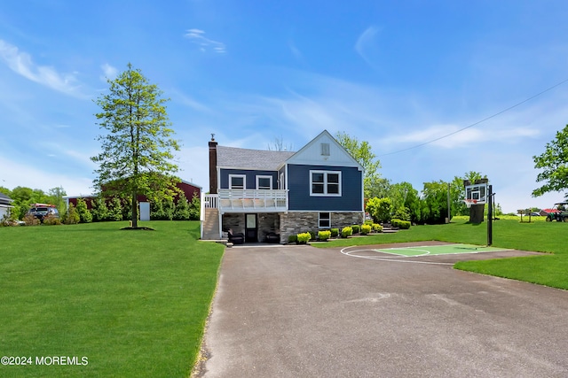 view of front facade with basketball hoop and a front lawn