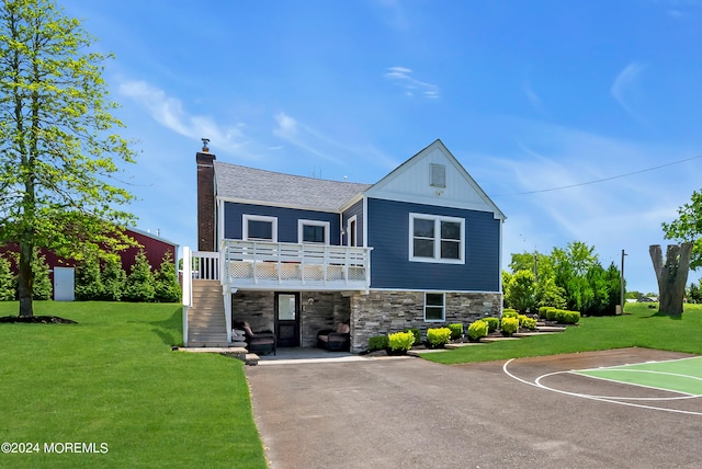 view of front of house with basketball hoop and a front lawn